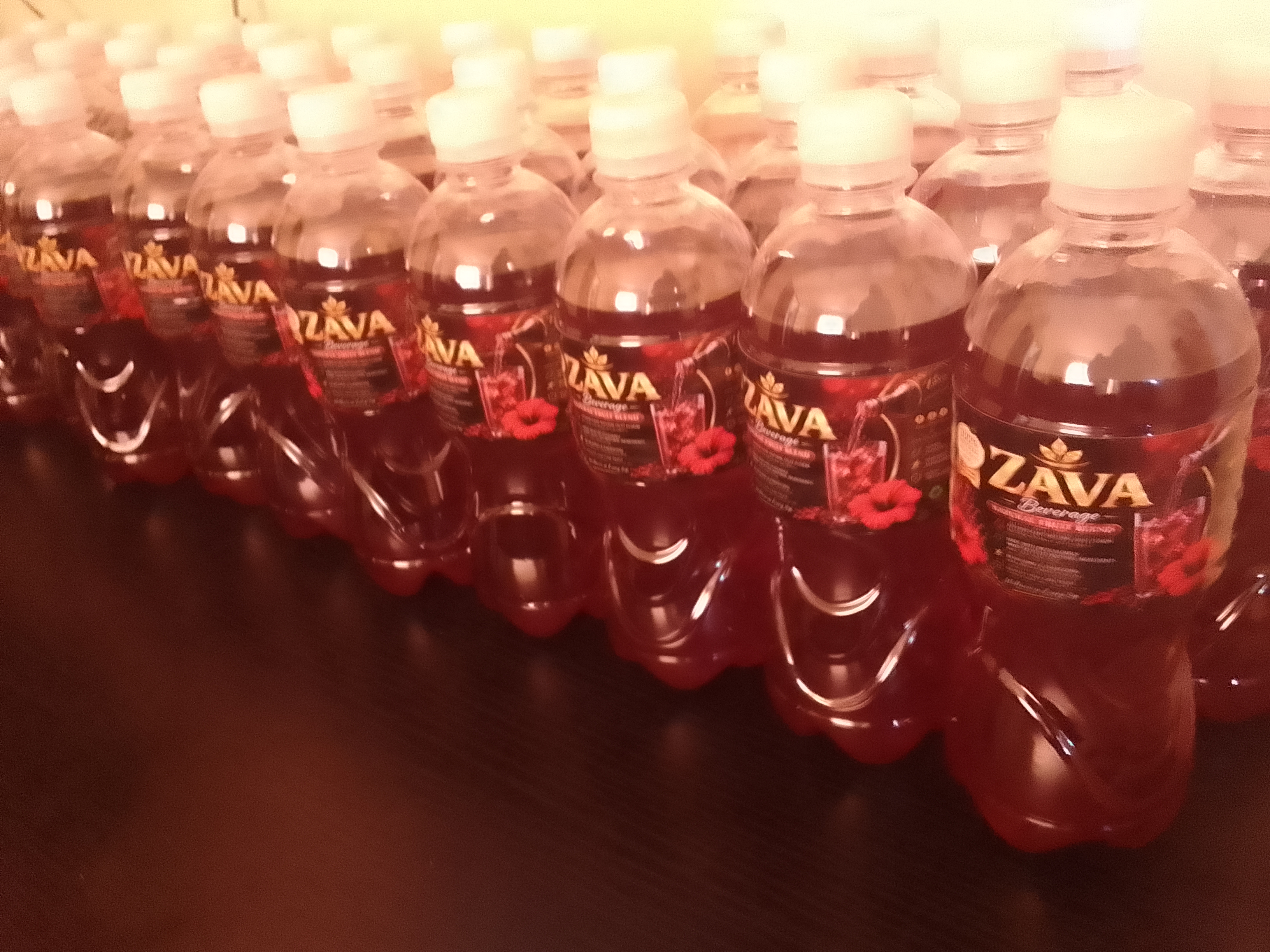 Rows of founder-produced ZAVA hibiscus beverage prototype bottles